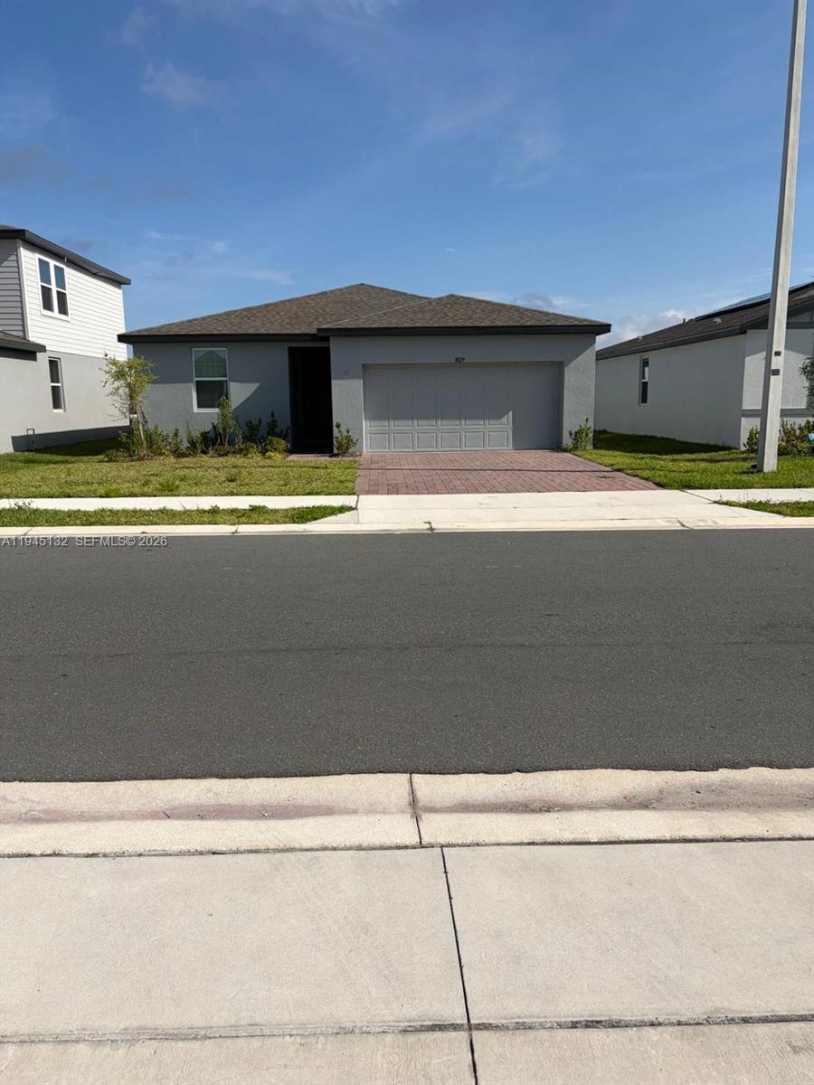 A single-story house with a gray exterior, a two-car garage, and a paved driveway — 3829 GIORGIO, Winter Haven FL 33884, WINTER HAVEN, FL