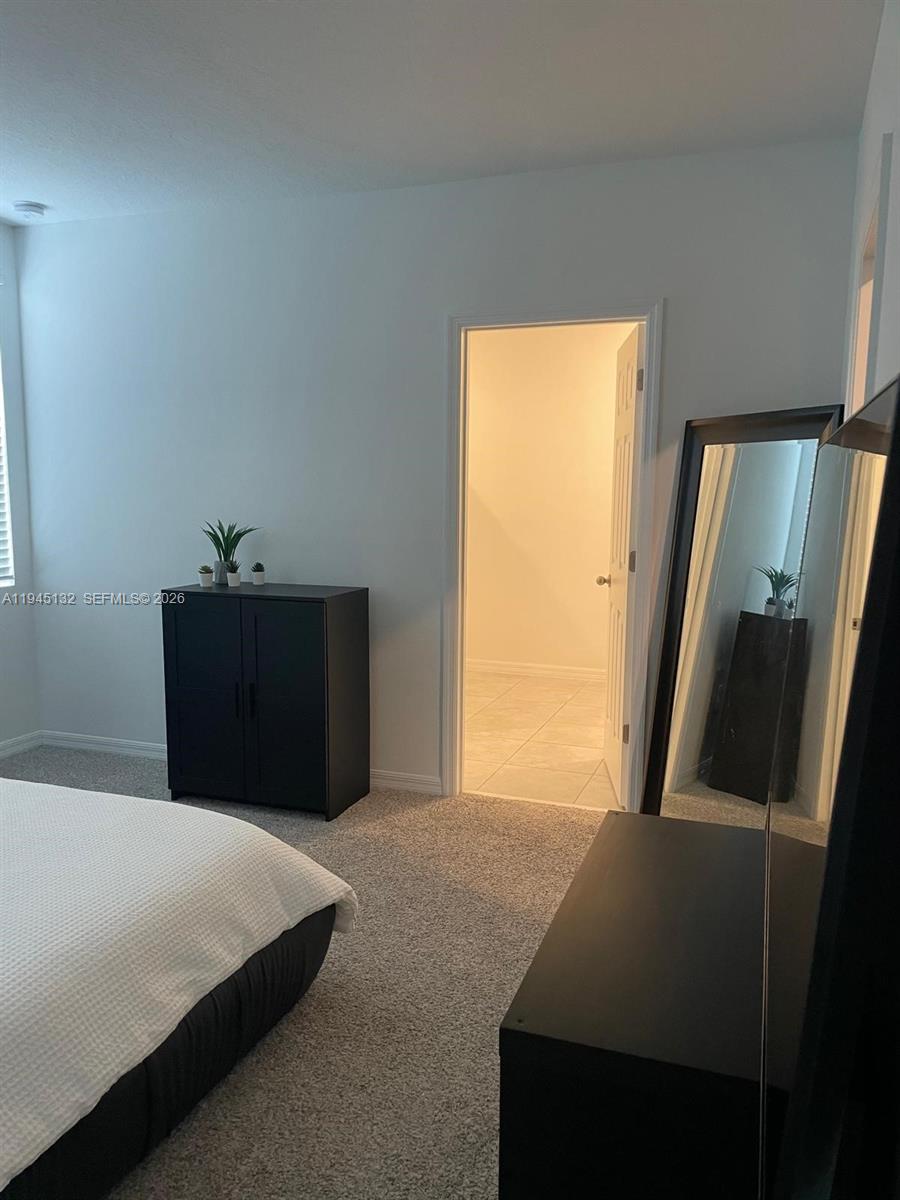 A bedroom features gray carpeting, a black cabinet, a floor mirror, and an open closet — 3829 GIORGIO, Winter Haven FL 33884, WINTER HAVEN, FL