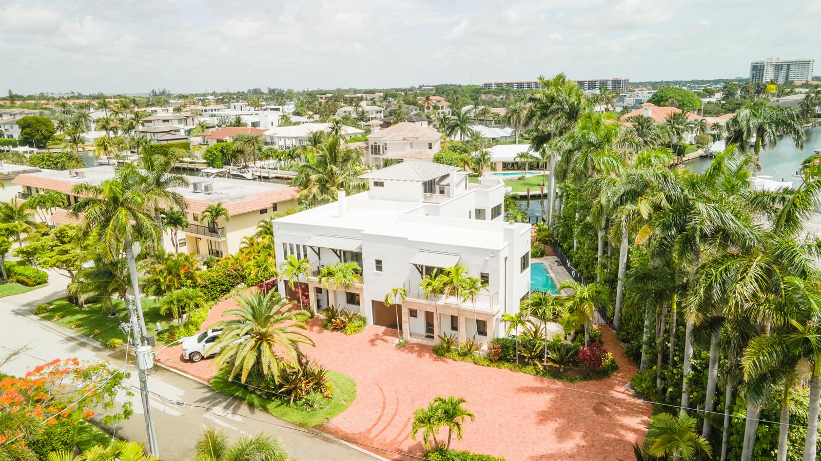 An aerial view of a white multi-story house with a red brick driveway and pool — 1121 Bel Air Drive, Highland Beach FL 33487, HIGHLAND BEACH, FL