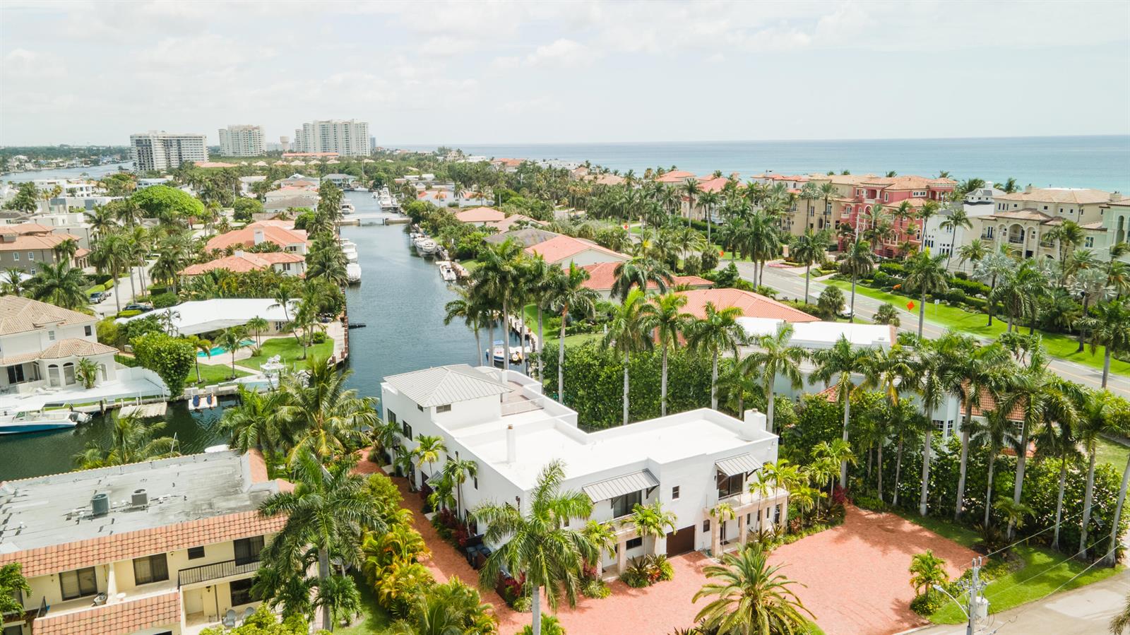 An aerial view shows a white house with a red driveway beside a canal — 1121 Bel Air Drive, Highland Beach FL 33487, HIGHLAND BEACH, FL