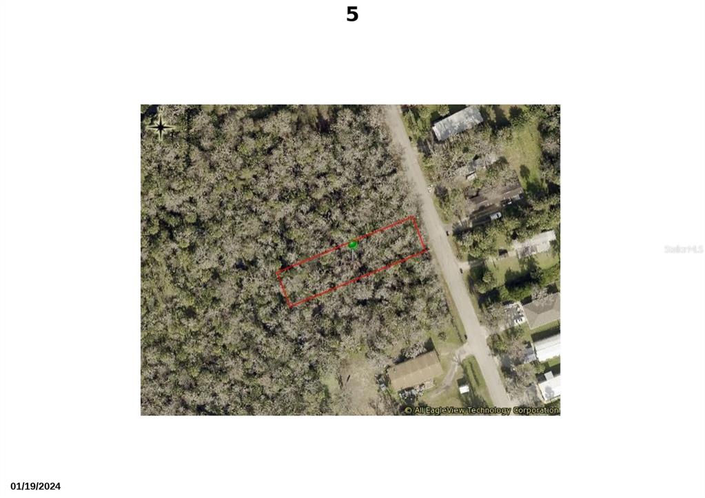 An aerial view shows a rectangular plot of land outlined in red near a road — 1310 ELIZABETH STREET, NEW SMYRNA BEACH, FL