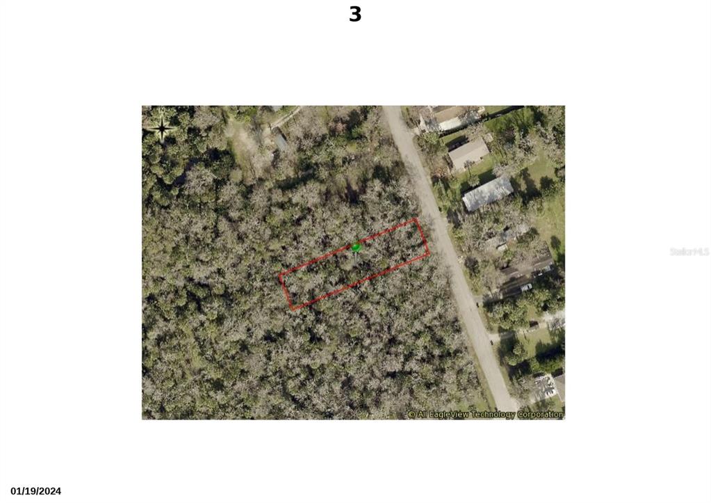 An aerial view shows a rectangular plot of land outlined in red near a road — 1310 ELIZABETH STREET, NEW SMYRNA BEACH, FL