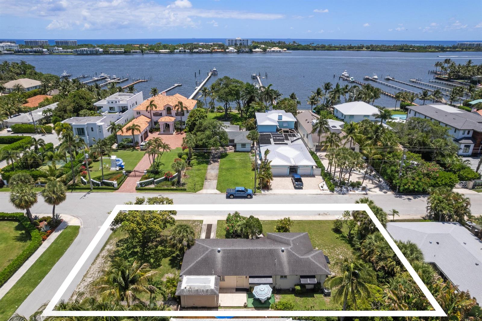 An aerial view shows a single-story house with a dark roof and surrounding landscaping — 1725 N Lakeside Drive, FL 33460, FL