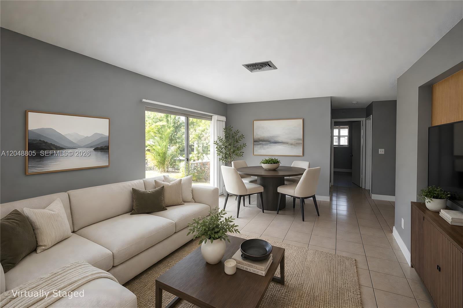 This living and dining area features gray walls, tile flooring, and a sliding glass door — 825 SW 10th St # C, Hallandale Beach FL 33009, HALLANDALE BEACH, FL