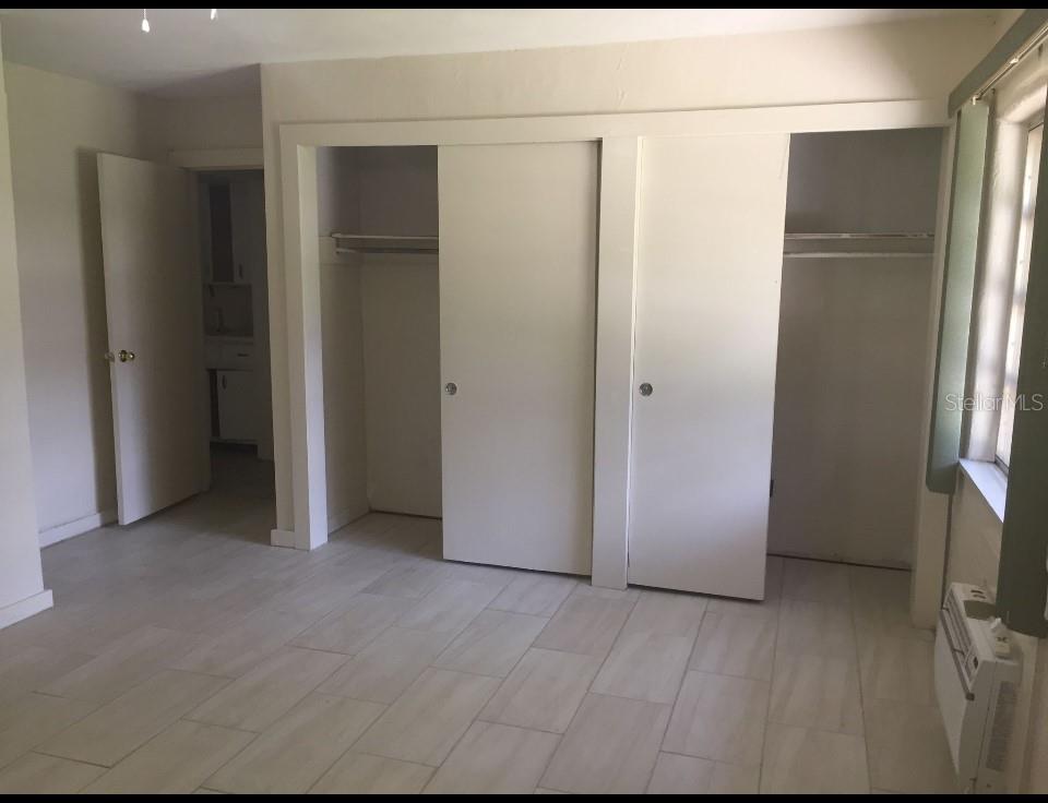 A room with light-colored tile flooring, white walls, and a multi-section sliding closet — 226 WILDWOOD AVENUE, EDGEWATER, FL