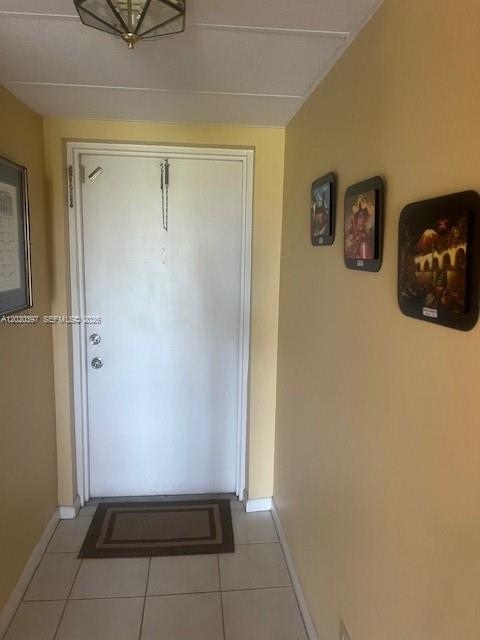 An entryway features a white door, light-colored tile flooring, and three framed pictures on the wall — 7797 Golf Cir Dr # 310, Margate FL 33063, MARGATE, FL