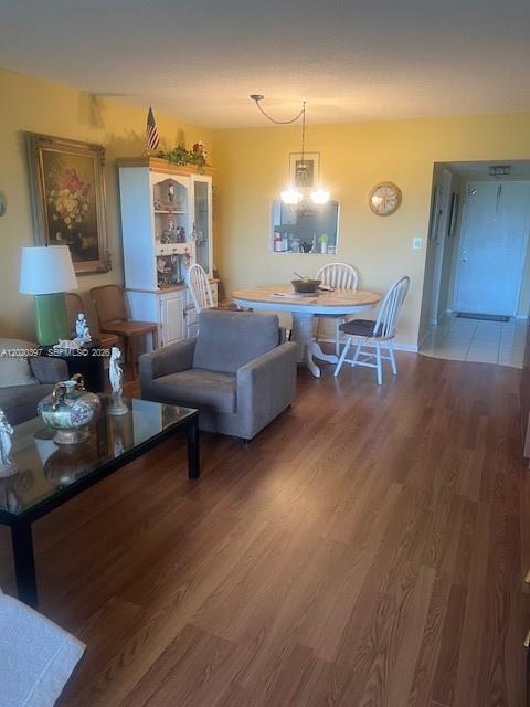 This living and dining area features wood-look flooring, yellow walls, and a round dining table — 7797 Golf Cir Dr # 310, Margate FL 33063, MARGATE, FL