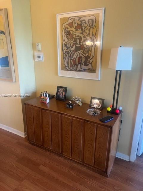 A wooden sideboard sits against a yellow wall beneath a framed print and lamp — 7797 Golf Cir Dr # 310, Margate FL 33063, MARGATE, FL