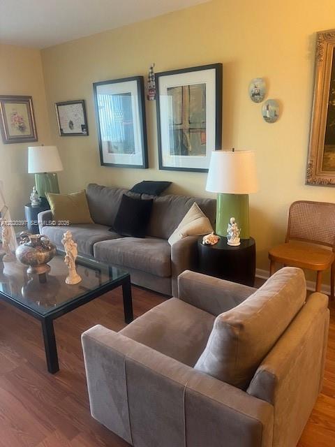 A living room features a grey sofa, matching armchair, glass coffee table, and framed wall art — 7797 Golf Cir Dr # 310, Margate FL 33063, MARGATE, FL