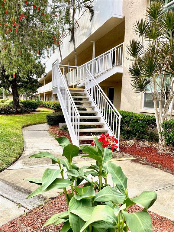 An outdoor staircase with white railings leads to the second floor of a building — 10032 65TH AVENUE N UNIT 17, ST PETERSBURG, FL