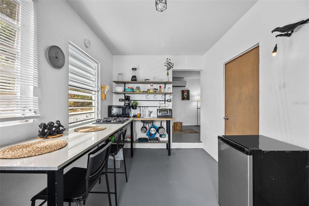A small kitchen features a breakfast bar, open shelving, and a compact refrigerator — JJ-30 CALLE 10, CAYEY, PR