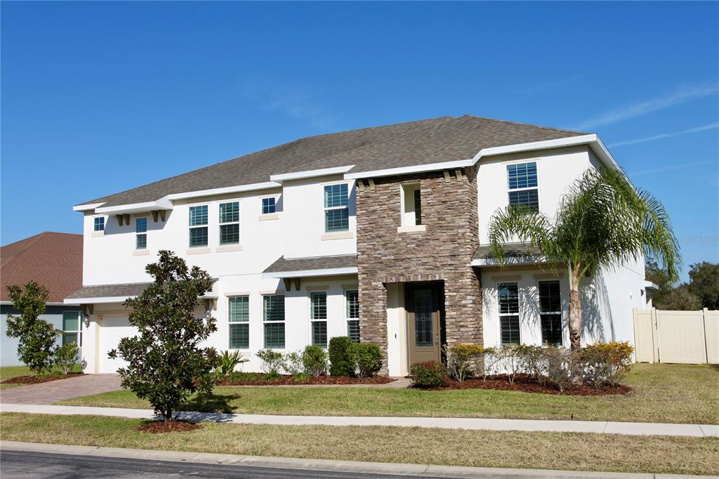 A two-story house with a stone facade, white stucco walls, and a multi-car garage — 5412 CAMBERWELL LANE, RIVERVIEW, FL