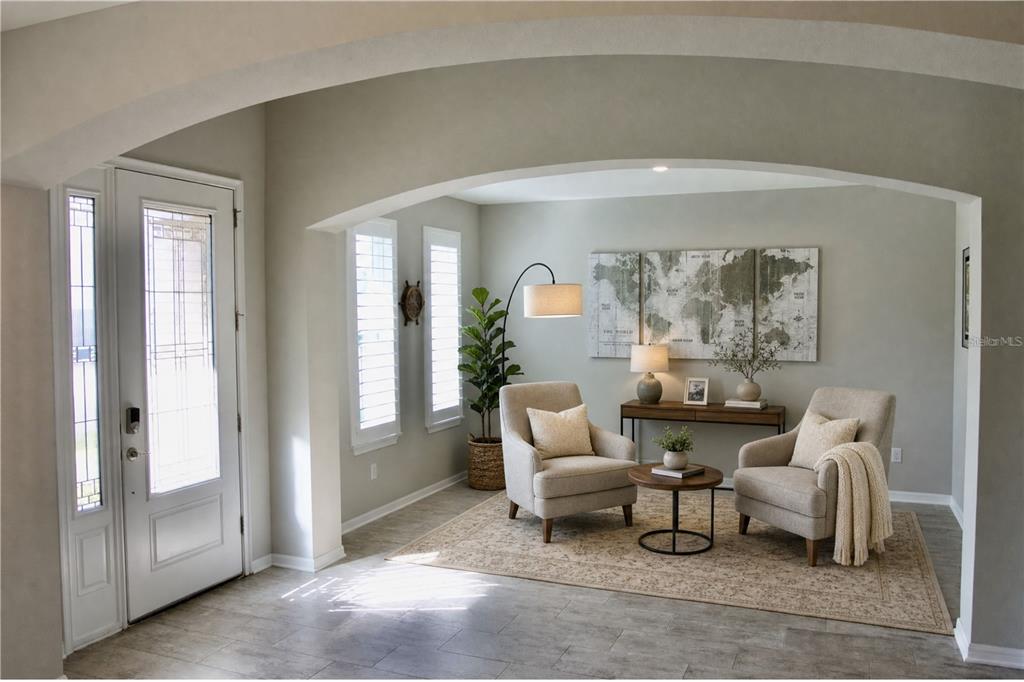 A bright foyer features a seating area with two armchairs under a large arched opening — 5412 CAMBERWELL LANE, RIVERVIEW, FL