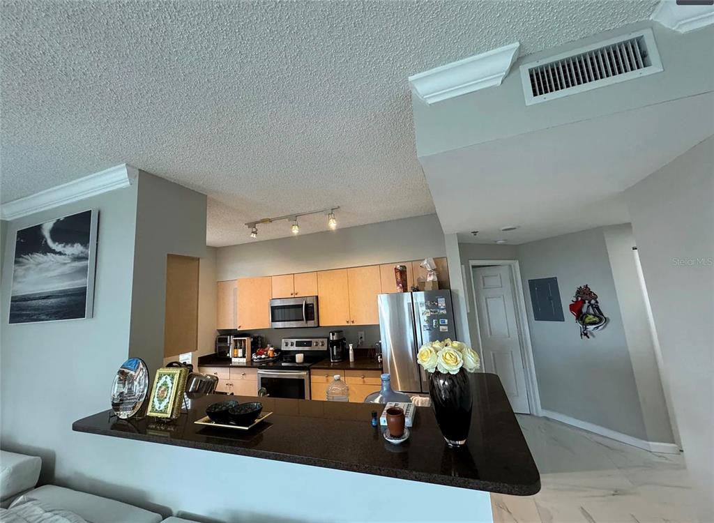 A kitchen with light wood cabinets, stainless steel appliances, and a dark granite breakfast bar — 616 CLEARWATER PARK ROAD UNIT 1002, WEST PALM BEACH, FL