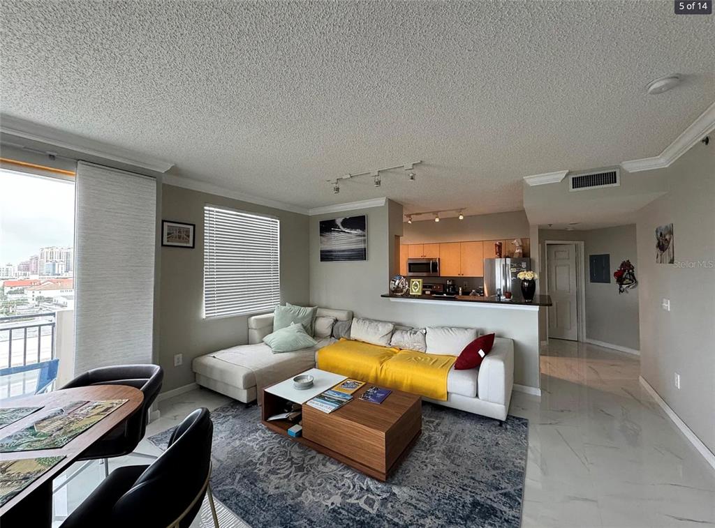 A living room with a sectional sofa, coffee table, and an open kitchen with bar seating — 616 CLEARWATER PARK ROAD UNIT 1002, WEST PALM BEACH, FL