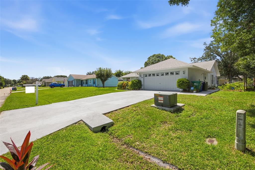 A single-story house with a white garage and a concrete driveway sits on a lawn — 881 FOSTER AVENUE, SEBASTIAN, FL