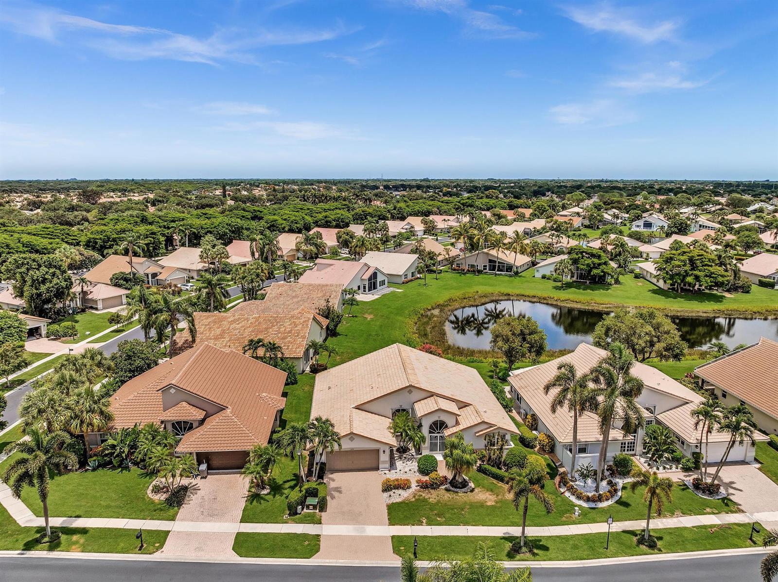 An aerial view of a suburban neighborhood featuring houses with tile roofs and a pond — 12316 Lakeridge Falls Drive, Boynton Beach FL 33437, BOYNTON BEACH, FL