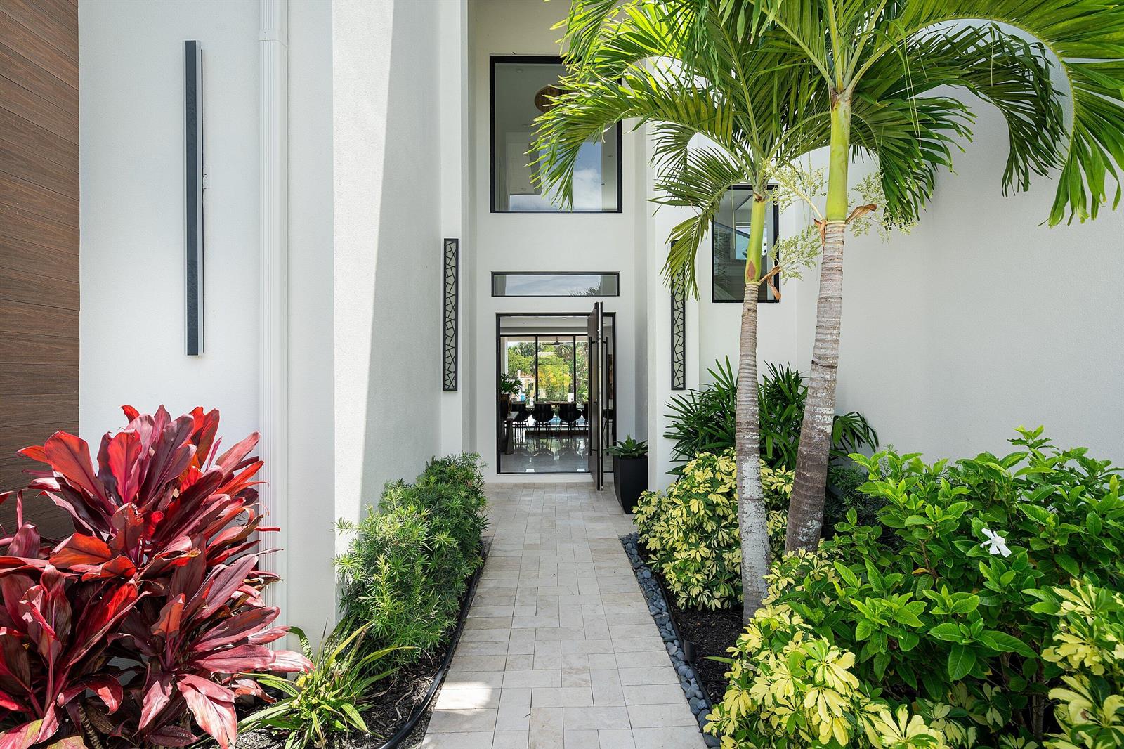 A stone walkway leads to the modern glass front entrance of a white stucco home — 798 Havana Drive, Boca Raton FL 33487, BOCA RATON, FL