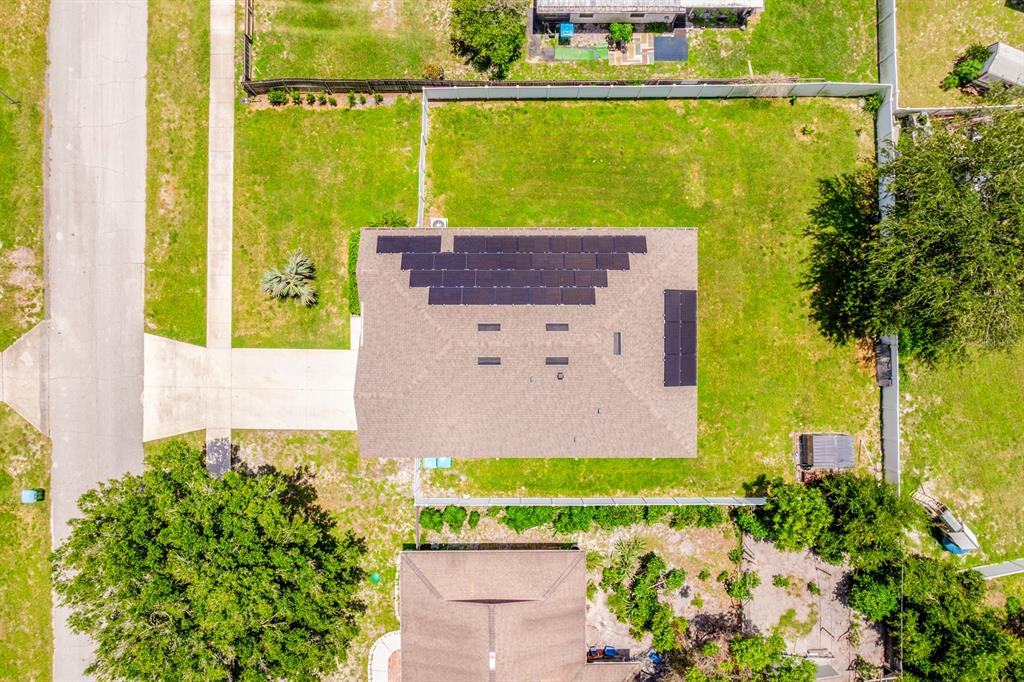 An aerial view shows a house with solar panels on the roof and a backyard — 1191 ABAGAIL DRIVE, DELTONA, FL