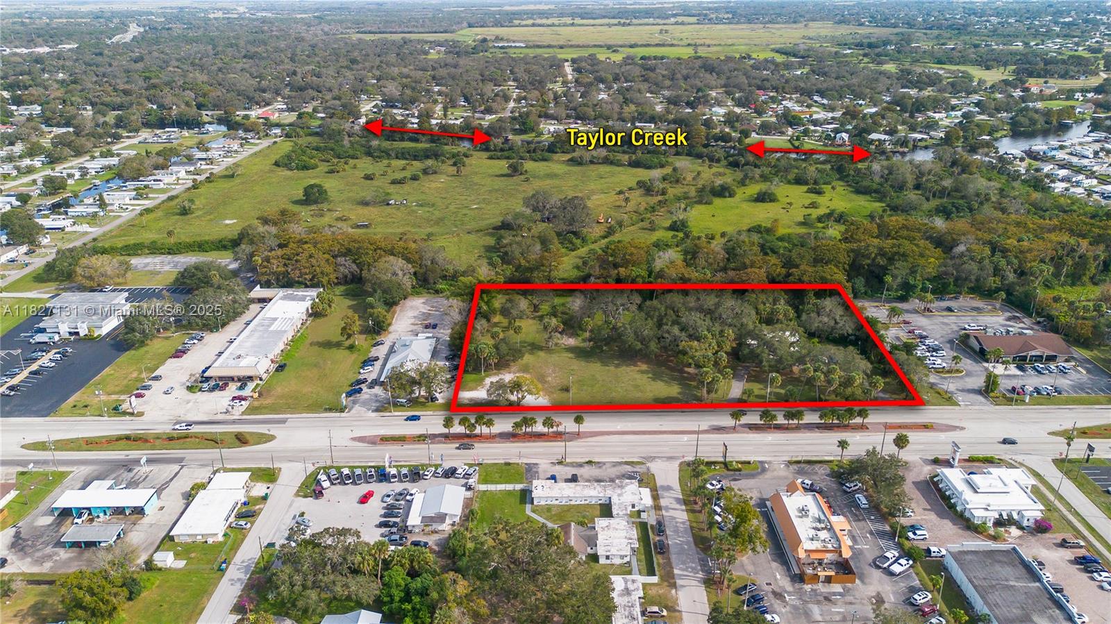 An aerial view shows a rectangular vacant lot outlined in red along a busy road — 1011 S. PARROTT, Okeechobee FL 34972, OKEECHOBEE, FL