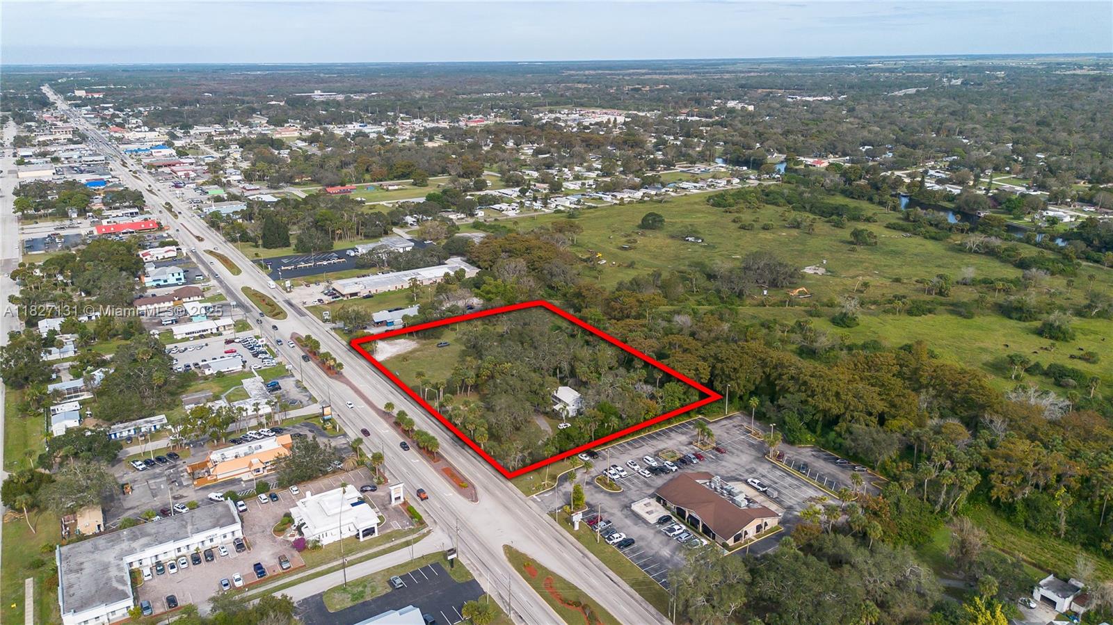 An aerial view shows a rectangular plot of land outlined in red near a road — 1011 S. PARROTT, Okeechobee FL 34972, OKEECHOBEE, FL