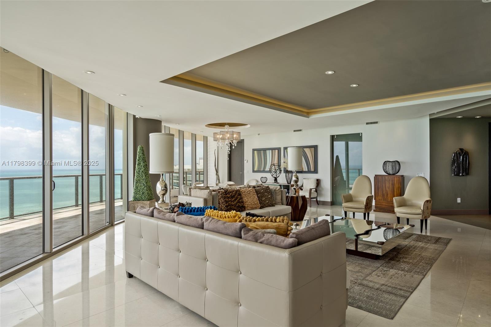 A modern living room features a tufted sofa, floor-to-ceiling windows, and ocean views — 9703 Collins Ave # 2100, Bal Harbour FL 33154, BAL HARBOUR, FL