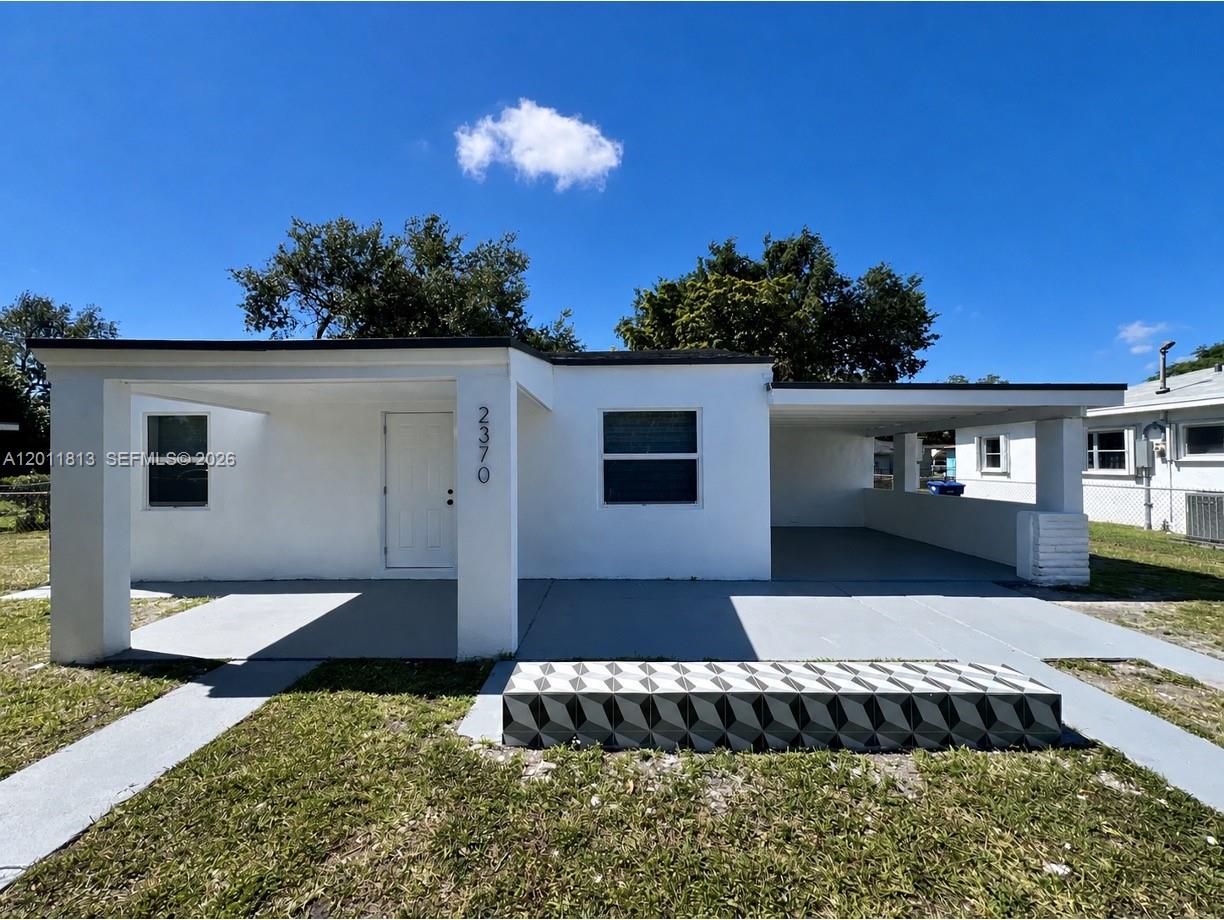 A white single-story house features a front porch, a carport, and a patterned concrete step — 2370 NW 96th St, Miami FL 33147, MIAMI, FL