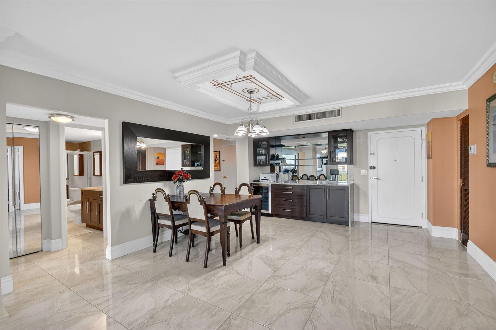 A dining area features a wooden table, chairs, a wet bar, and tile flooring — 3450 S Ocean Boulevard # 423, Palm Beach FL 33480, PALM BEACH, FL