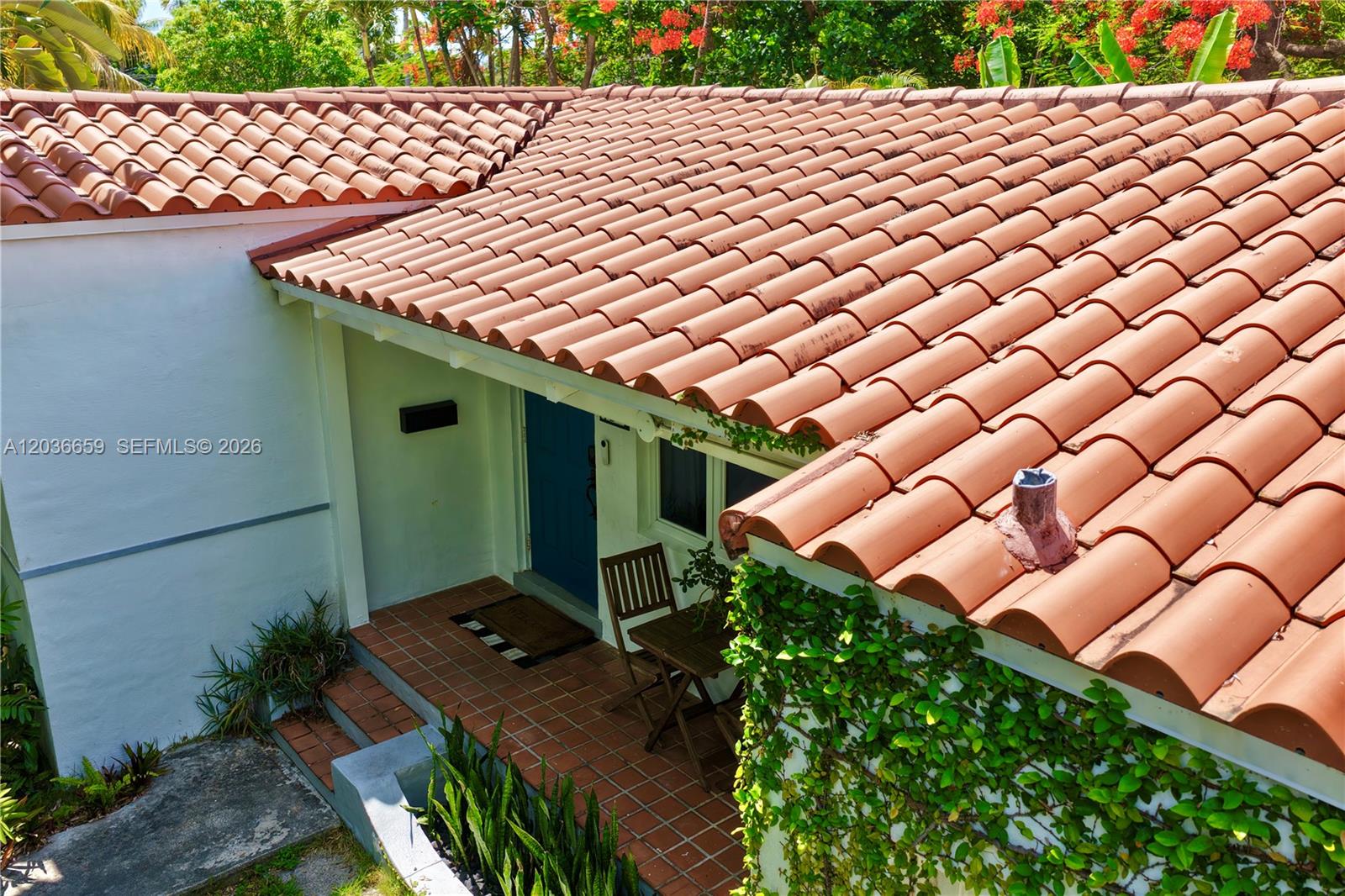 A high-angle view shows a tiled roof over a small patio with a blue door — 454 NE 76th St, Miami FL 33138, MIAMI, FL