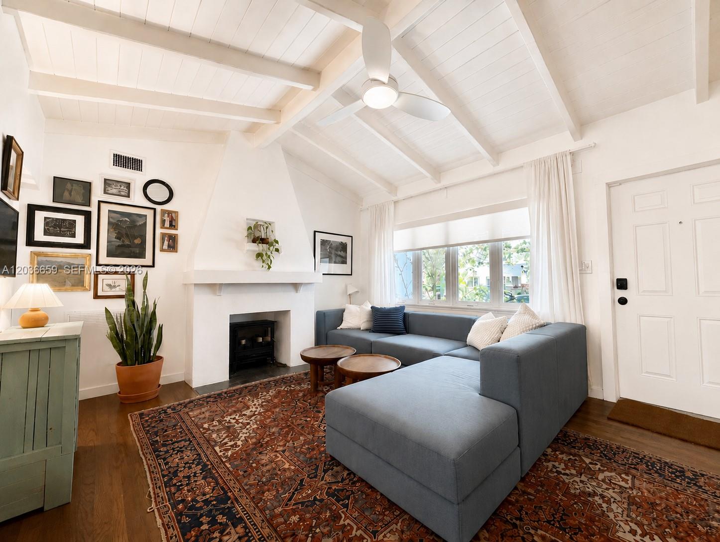 A living room features a white fireplace, a blue sectional sofa, and a patterned rug — 454 NE 76th St, Miami FL 33138, MIAMI, FL