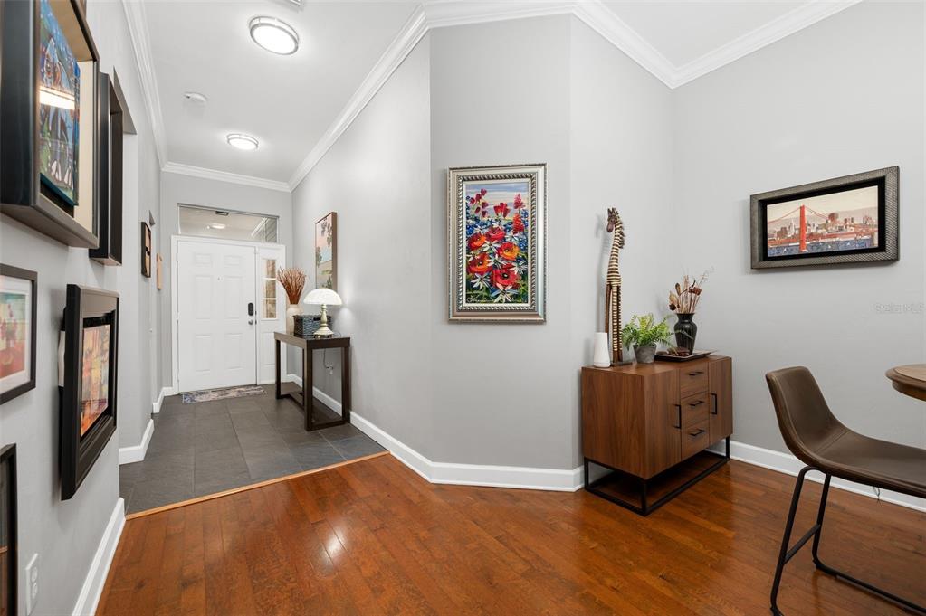 An entryway features a white front door, gray walls, hardwood flooring, and several framed artworks — 9044 SW 25TH ROAD, GAINESVILLE, FL