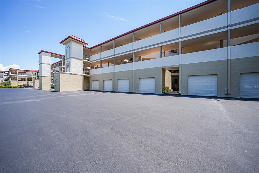 An exterior view of a multi-story apartment building with ground-level parking garages — 3230 SOUTHSHORE DRIVE UNIT 34A, PUNTA GORDA, FL