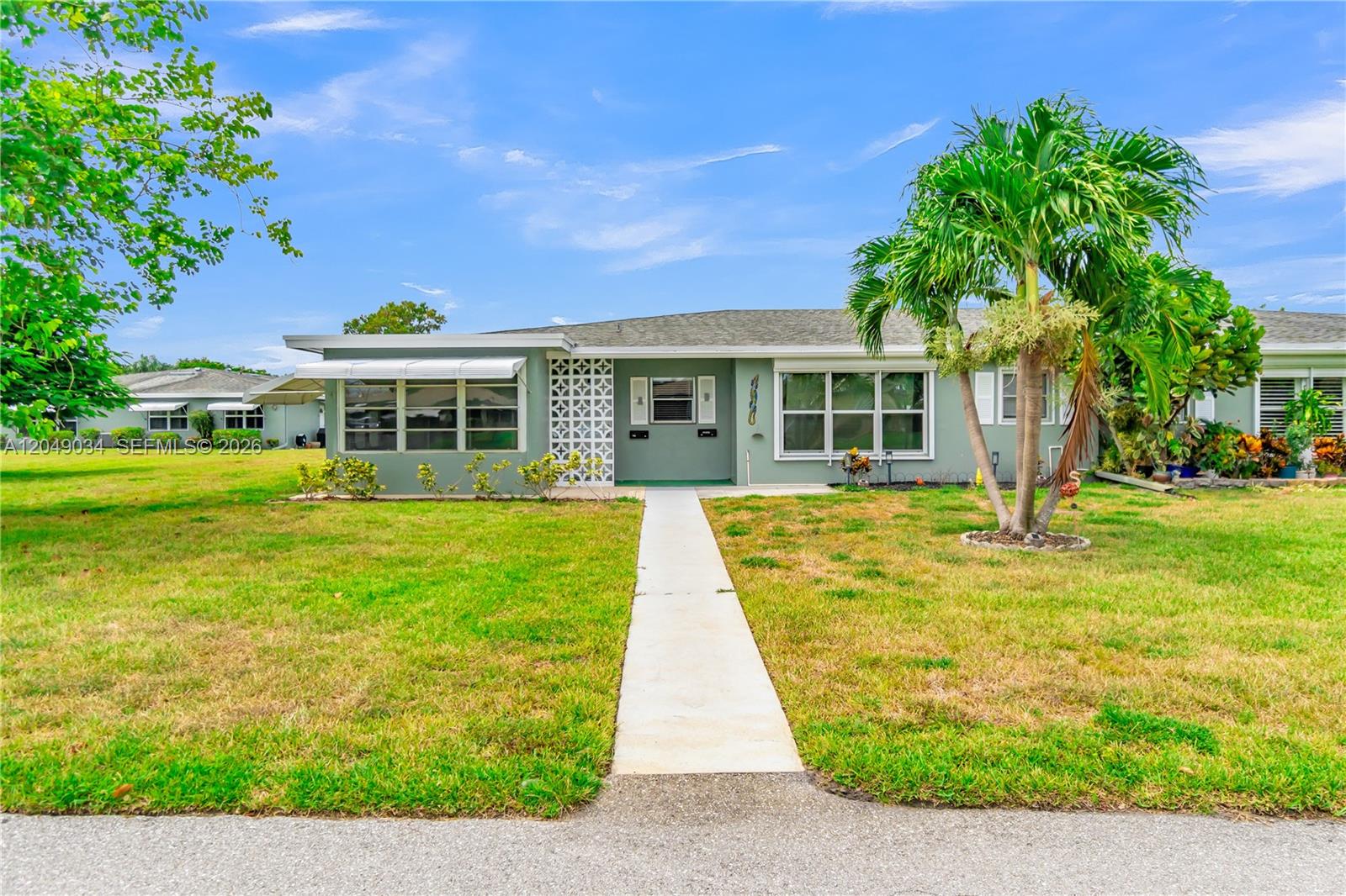 A single-story house with a green exterior, a front walkway, and a palm tree — 775 North Dr # A, Delray Beach FL 33445, DELRAY BEACH, FL
