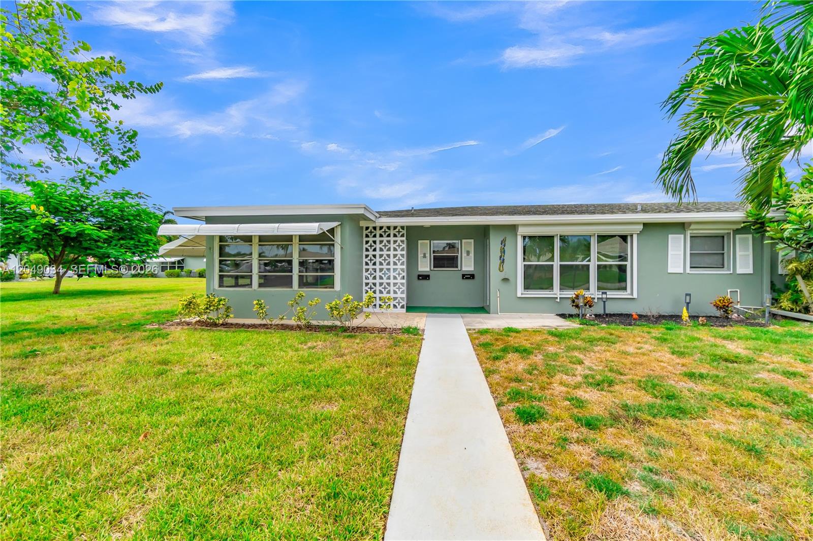 A single-story house with green siding, a concrete walkway, and decorative breeze block accents — 775 North Dr # A, Delray Beach FL 33445, DELRAY BEACH, FL