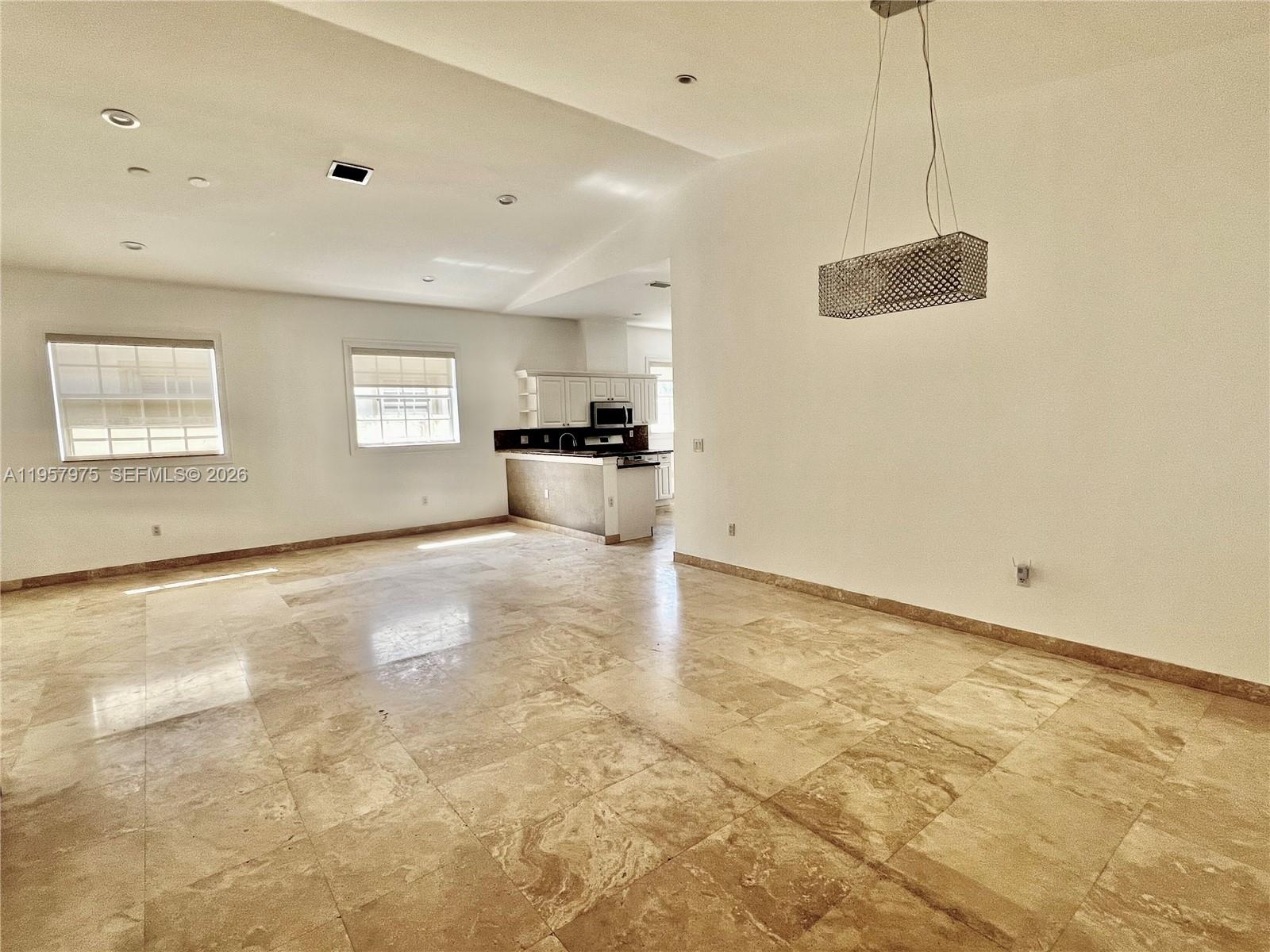 An open-concept living area features large beige floor tiles and a modern rectangular pendant light — 2301 SW 22nd Ave, Miami FL 33145, MIAMI, FL