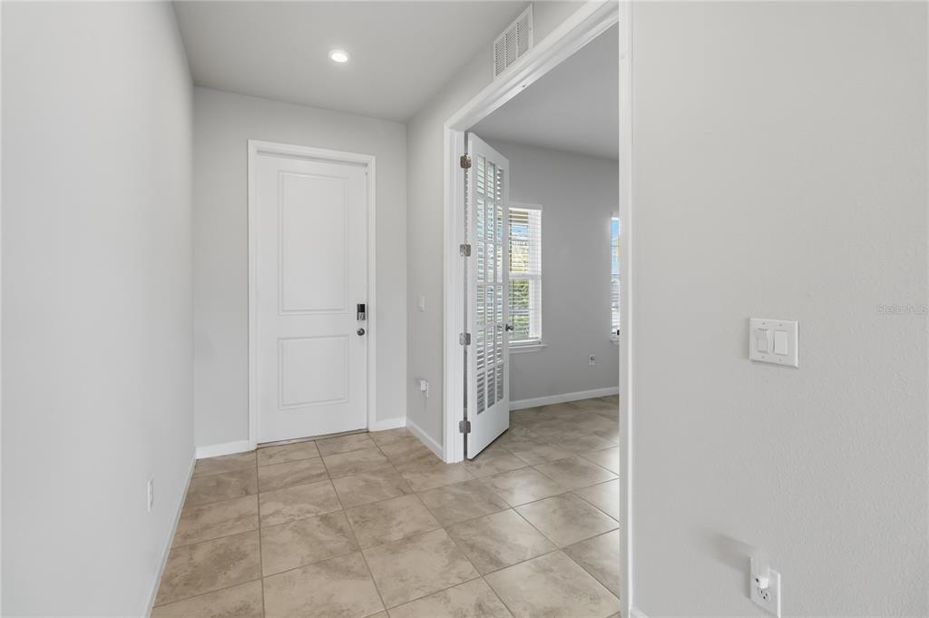 A tiled entryway leads to a room with white doors and light gray walls — 5581 VIGO LOOP, ST CLOUD, FL