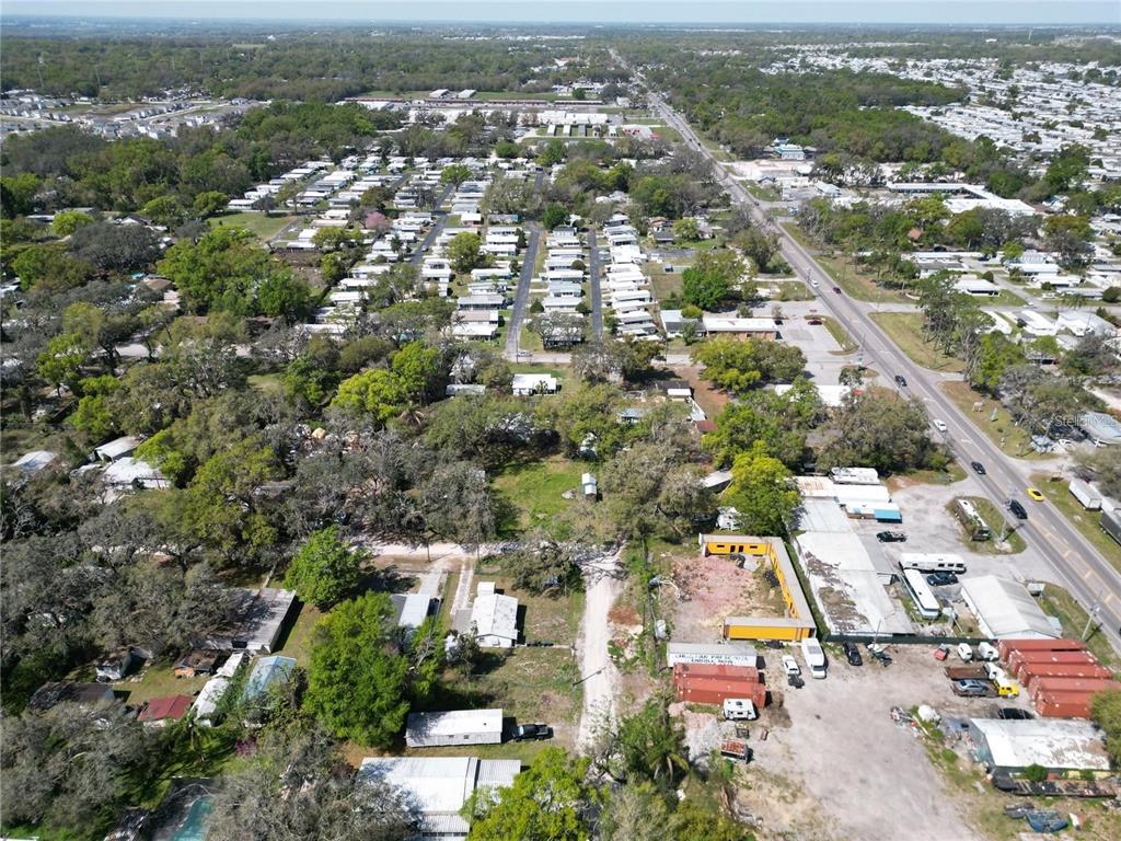 An aerial view shows a residential area with mobile homes, trees, and a nearby road — 4919 HURON STREET, ZEPHYRHILLS, FL
