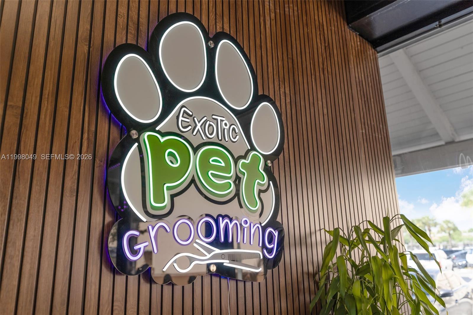 A wall-mounted, illuminated sign for a pet grooming business features a paw print design — 13790 SW 56th St, Miami FL 33183, MIAMI, FL