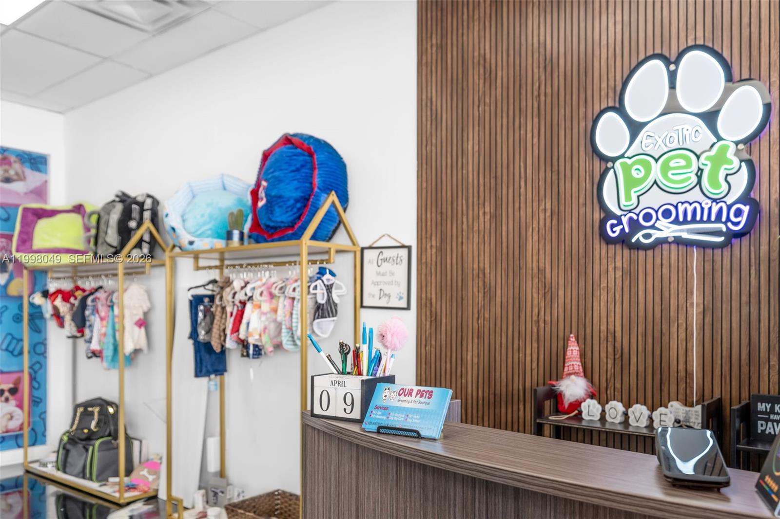 A pet grooming shop features a reception desk, clothing racks, and a branded wall sign — 13790 SW 56th St, Miami FL 33183, MIAMI, FL
