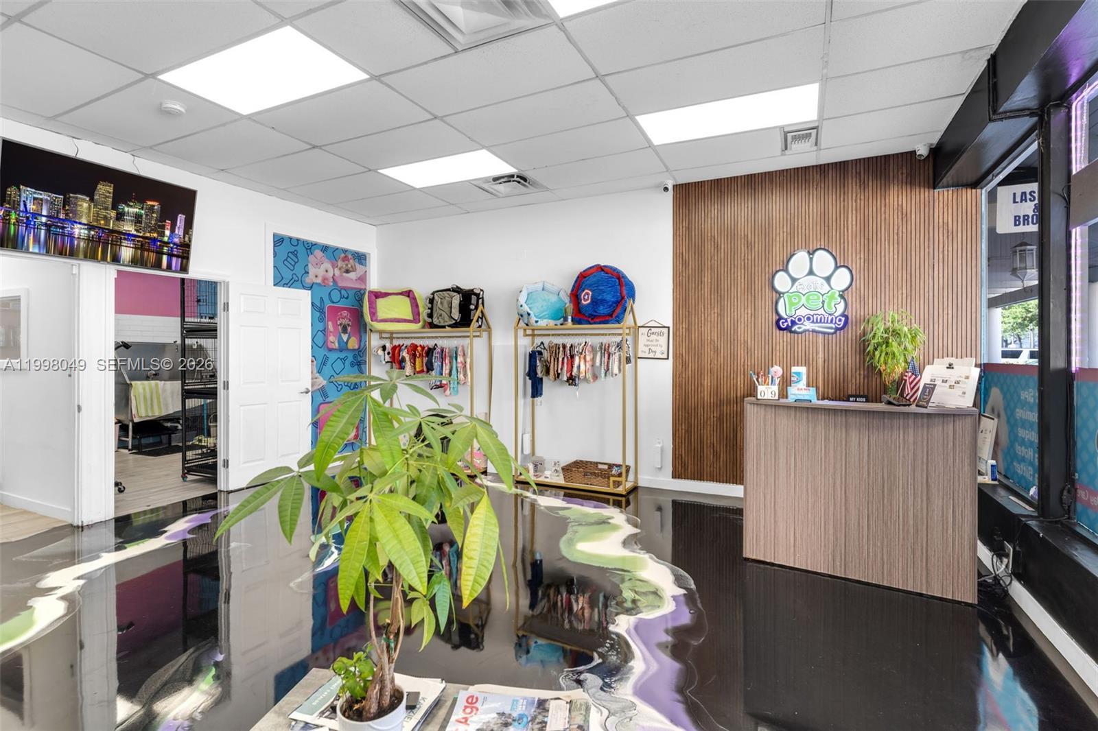A pet grooming shop reception area features a wood-paneled wall, a front desk, and decorative flooring — 13790 SW 56th St, Miami FL 33183, MIAMI, FL