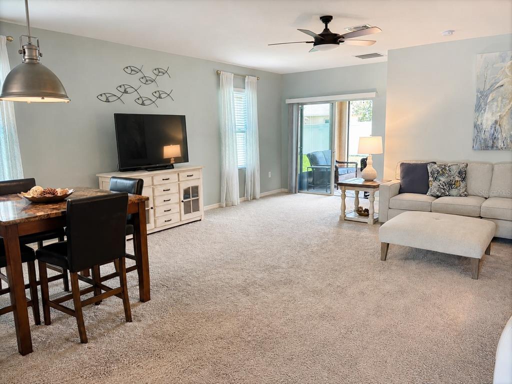 A living room features a dining area, a television console, and a sectional sofa — 2719 STAR CORAL LANE, NEW SMYRNA BEACH, FL