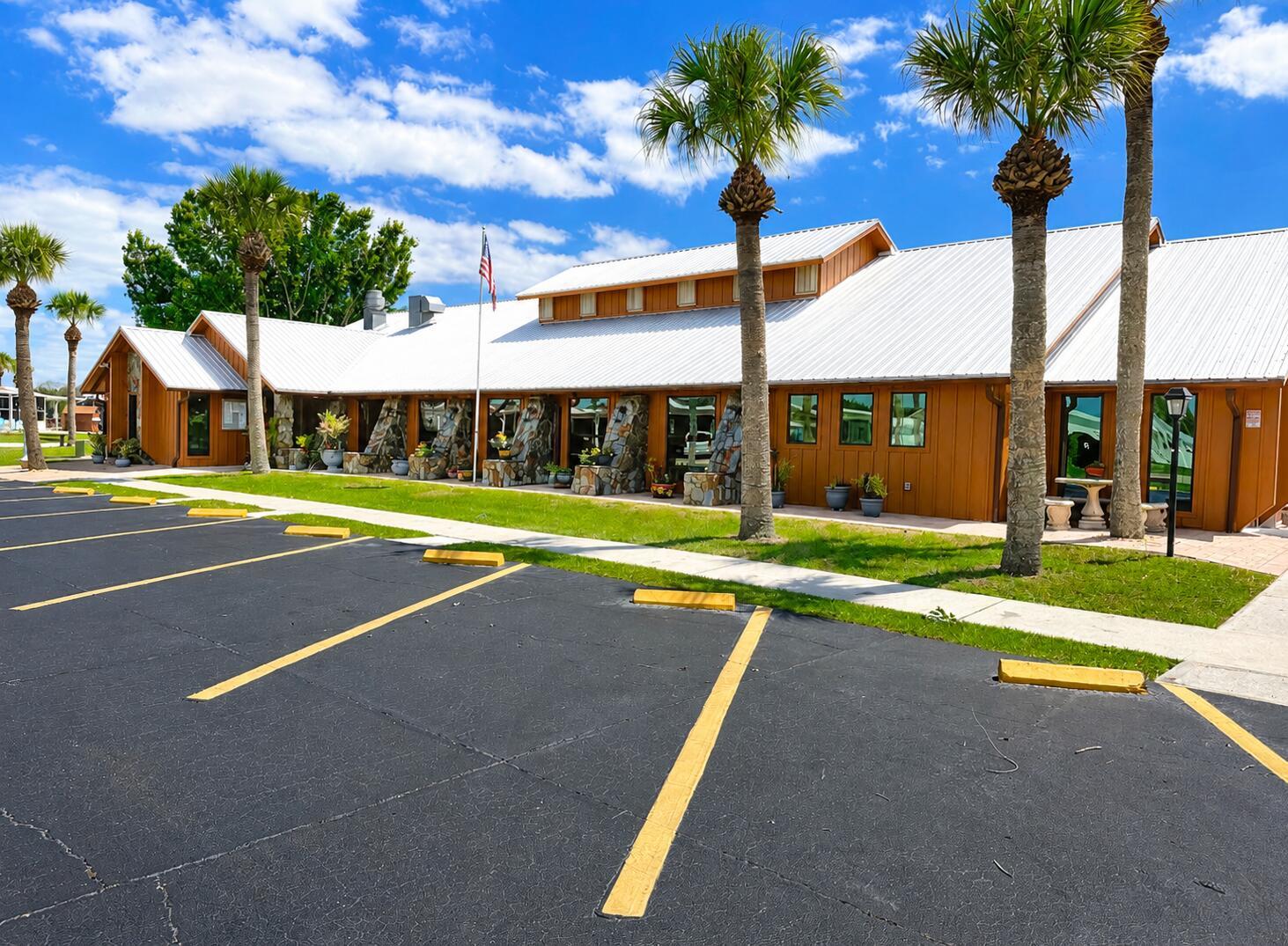 A low-rise building with a metal roof and stone accents sits behind a parking lot — 6472 SE 55th Lane, Okeechobee FL 34974, OKEECHOBEE, FL