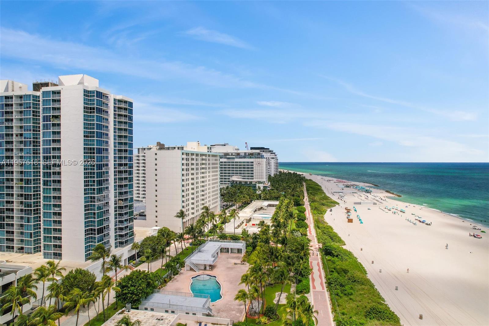 An aerial view shows a beach, a swimming pool, and several high-rise residential buildings — 2655 Collins Ave # 2301, Miami Beach FL 33140, MIAMI BEACH, FL