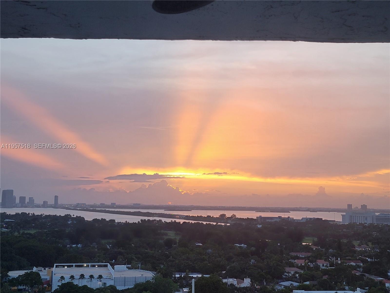 An elevated view of a sunset over a body of water and a city skyline — 2655 Collins Ave # 2301, Miami Beach FL 33140, MIAMI BEACH, FL