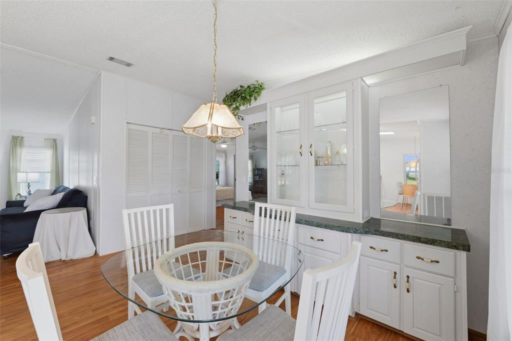 A dining area features a glass-topped table, white chairs, and a built-in white hutch — 520 TIVOLI PARK DRIVE, DAVENPORT, FL