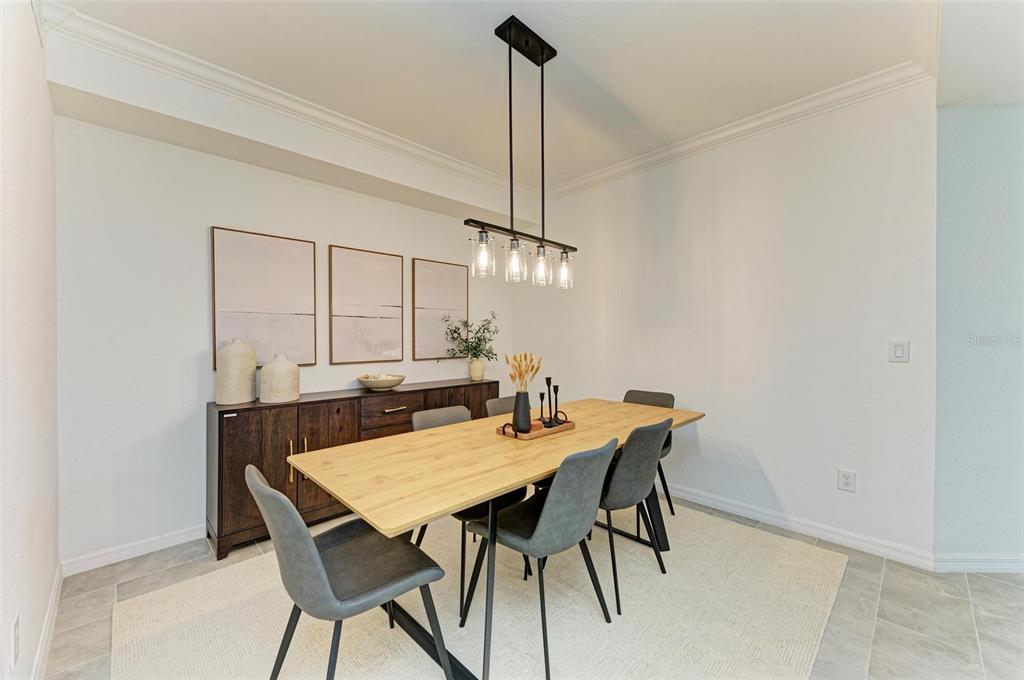 A dining room features a light wood table, grey chairs, and a dark wood sideboard — 18114 GAWTHROP DRIVE UNIT 108, BRADENTON, FL