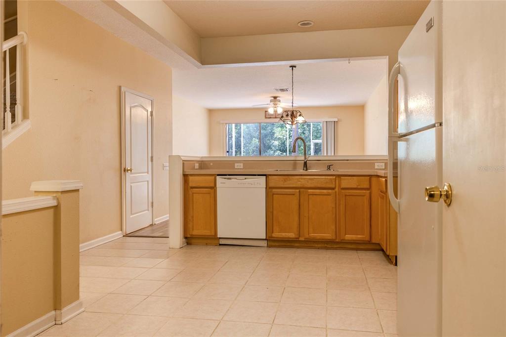 A kitchen with light wood cabinets, a white dishwasher, and tile flooring — 2720 CONCH HOLLOW DRIVE, BRANDON, FL