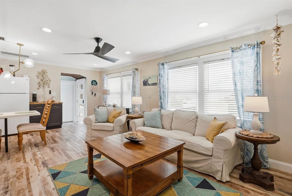 A living room features a white sofa, wooden coffee table, and light wood flooring — 118 92ND AVENUE, TREASURE ISLAND, FL