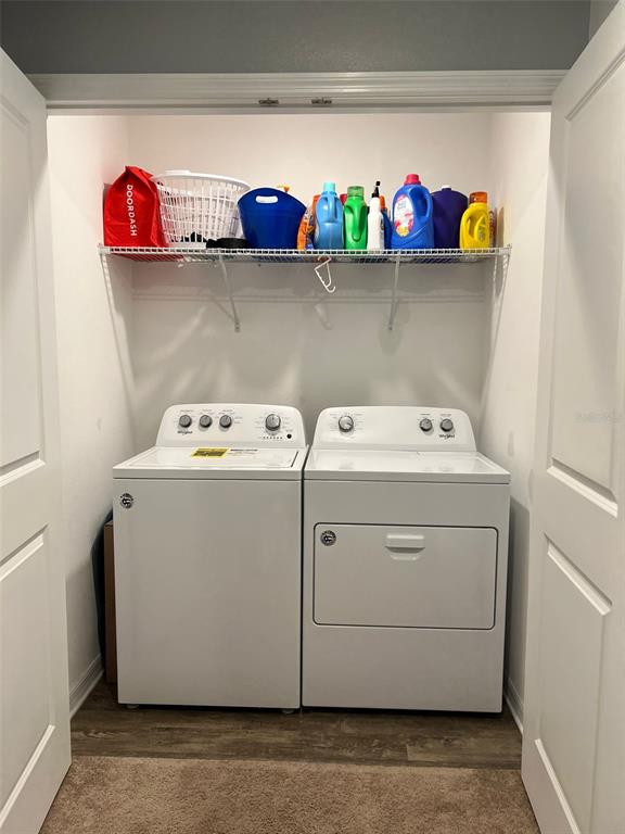 A laundry closet contains a white washer and dryer beneath a wire storage shelf — 863 GRANDIN STREET, DAVENPORT, FL