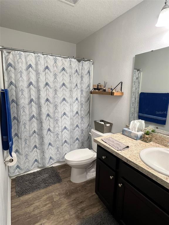 A bathroom features a shower with a patterned curtain, a toilet, and a dark vanity — 863 GRANDIN STREET, DAVENPORT, FL
